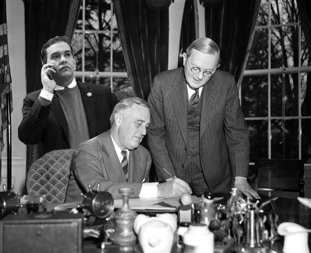 George Santos looks on as President Franklin Delano Roosevelt signs legislation on April 1, 1940